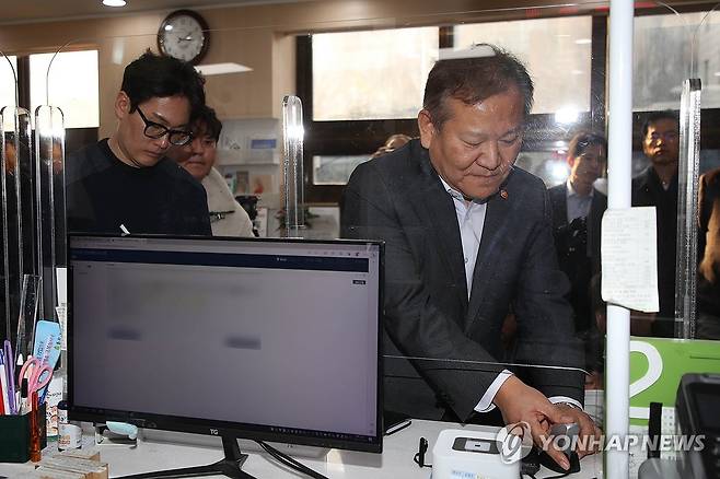 이상민 장관, 행정전산망 점검 위해 등본·인감 발급 (서울=연합뉴스) 임화영 기자 = 이상민 행정안전부 장관이 19일 오후 서울 종로구 청운효자동주민센터를 방문해 사흘째 이어지고 있는 정부 행정전산망 장애 복구를 위한 현장점검 도중 본인의 등본과 인감 서류를 발급하기 위해 지문을 인식하고 있다. 
    지난 17일 공무원 전용 행정전산망인 '새올'에 이어 정부 온라인 민원서비스인 '정부24'도 서비스가 전면 중단돼 공공기관의 민원서류 발급이 올스톱됐다. 2023.11.19 [공동취재] hwayoung7@yna.co.kr