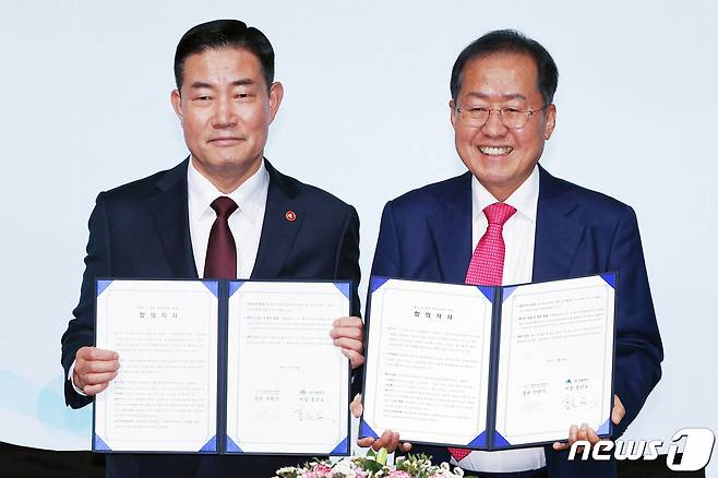 홍준표 대구시장(오른쪽)과 신원식 국방부 장관이 20일 오전 서울 영등포구 여의도 페어몬트 앰배서더 호텔에서 열린 '대구경북신공항 투자설명회'에서 합의각서 체결 뒤 환하게 웃고 있다. 2023.11.20/뉴스1 ⓒ News1 민경석 기자