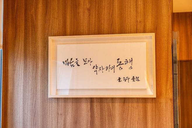 19일 오세훈 서울시장 집무실 한 켠에 ‘마음을 모아 약자와의 동행’이라는 내용의 캘리그래피가 걸려 있다. 오 시장이 올 7월  서울 용산구 동자동 쪽방촌의 윤 씨 집에 방문했을 때 직접 글씨를 써 선물했다고 한다.  서울시 제공