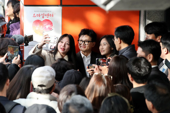 한동훈 법무부 장관이 17일 오후 대구 수성구 만촌동 대구스마일센터를 찾아 직원 간담회를 마친 뒤 입구에서 기다리던 시민들의 요청에 기념촬영을 하고 있다. 뉴스1