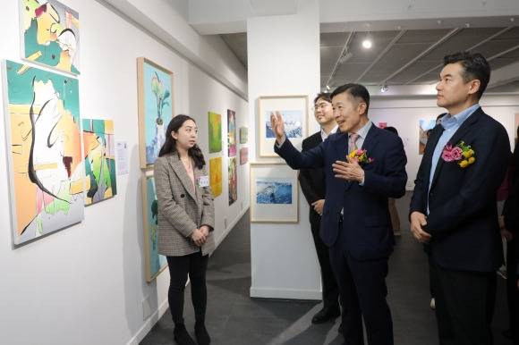 전성수(오른쪽 두 번째) 서울 서초구청장이 지난달 31일 서초구 방배동 유중아트센터에서 열린 청년작가 갤러리 개막식에 참석해 작품 설명을 듣고 이야기하고 있다. 서초구 제공