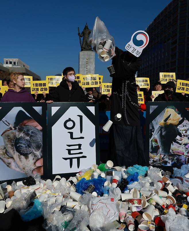 환경단체 활동가들이 21일 서울 광화문광장에서 정부의 일회용품 사용 규제 철회를 규탄하는 전국 공동행동에 참여해 퍼포먼스를 벌이고 있다. 연합뉴스.