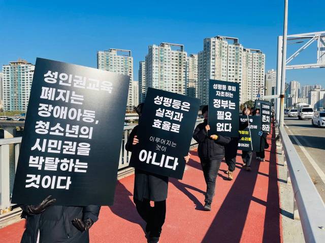 ▲ '여성폭력 방지 및 피해자 지원 예산 감축 철회 촉구 공동행동'이 11월 21일이 검은색 손팻말을 든 채 서강대교를 건너고 있다. ⓒ한국여성단체연합