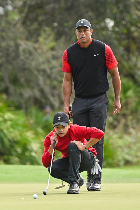 Tiger Woods and his son, Charlie Woods, read the third green during the final round of the PGA Tour Champions PNC Championship at The Ritz-Carlton Golf Club on Dec. 18, 2022 in Orlando, Florida. [GETTY IMAGES]