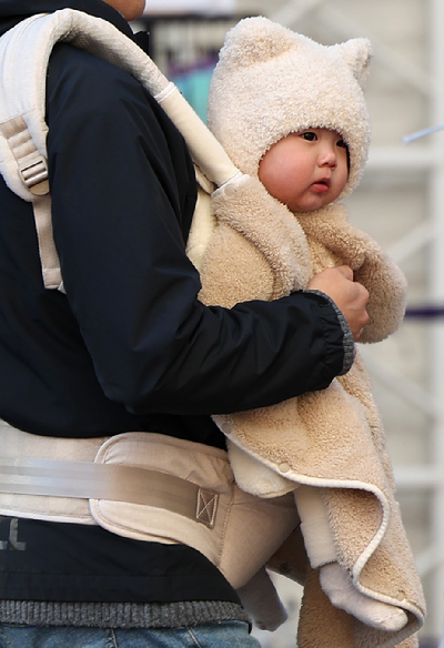 대구 중구 동성로에서 한 어린이가 담요를 두른 채 아빠 품에 안겨 있다. [사진=뉴시스]