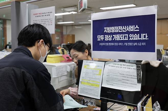 지난 20일 오전 광주 북구 용봉동 행정복지센터에서 민원인이 증명서 발급을 받고 있다. [사진 출처 = 연합뉴스]