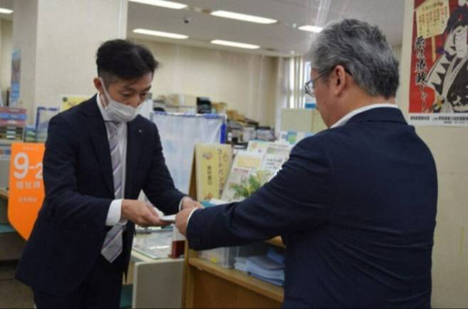 나카미치 무네히로 군마 사법 서사회 부회장(오른쪽)이 지난 21일 일본 군마 현 키류시 관공서에 생활보장수급자 생계 수급비 운용 개선을 요구하는 요청서를 시 담당자에게 전달하는 모습. 마이니치신문