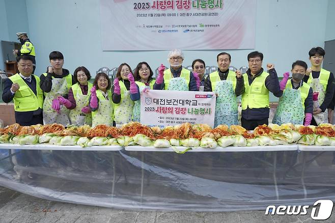 이병기 대전보건대 총장(오른쪽 여섯번째)과 교직원들이 '2023 사랑의 김장 나눔행사'에서 기념사진을 찍고 있다.(대전보건대 제공)/뉴스1