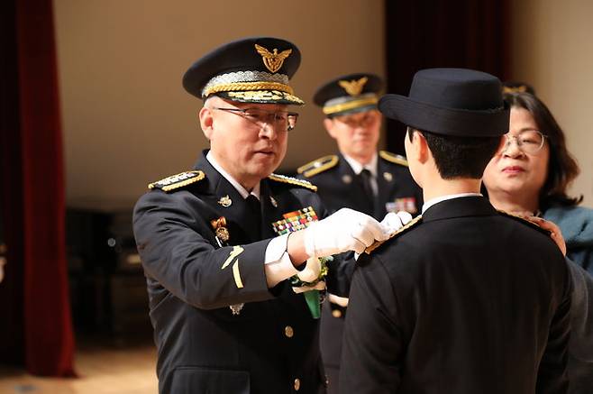 [여수=뉴시스] 김석훈 기자 = 24일 전남 여수시 오천동 해양경찰교육원 대강당에서 제247기 신임 해양경찰 졸업식이 열린 가운데 김종욱 해양경찰청장이 졸업생에게 계급장을 달아주고 있다. 남자 266명, 여자 54명 등 320명의 신임 해경이 졸업했다. (사진=해경교육원 제공) 2023.11.24. photo@newsis.com *재판매 및 DB 금지