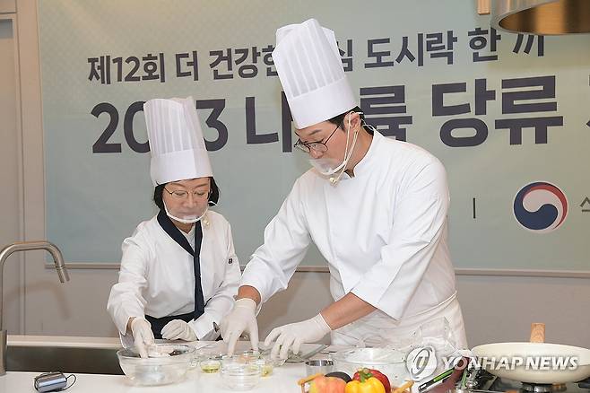 지난 9월 서울 송파구 배민아카데미 서울센터에서 열린 제12회 2023 나트륨·당류 저감요리 경연대회에서 오유경 식품의약품안전처장(왼쪽)이 오세득 요리연구가와 요리 시연을 하고 있다. [연합뉴스 자료사진]