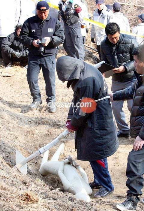 연쇄살인범 강호순이 경기도 화성시 비봉면 자안리 도로변에서 첫 번째 피해자의 암매장 장면을 재연하고 있다. /조선DB