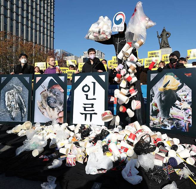 ‘1회용품 사용 규제 철회 규탄 전국공동행동’ 참여단체 활동가들이 지난 21일 오전 서울 광화문광장에서 환경부가 환경을 파괴하는 1회용품 쓰레기에 둘러싸여 있는 모습을 나타내는 행위극을 하고 있다. 김정효 기자