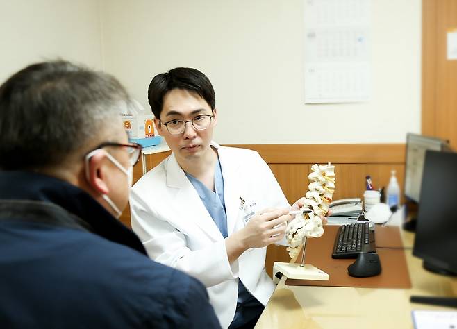 세란병원 척추내시경센터 최수용 과장이 환자에게 척추 압박골절의 원인에 대해 설명하고 있다./사진=세란병원