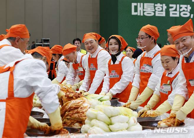 [고양=뉴시스] 조수정 기자 = 윤석열 대통령이 27일 경기 고양시 킨텍스에서 열린 나눔과 봉사의 국민 대통합 김장 행사에서 김치를 담그며 함게 김장을 담그는 참여자들과 대화를 나누고 있다. 2023.11.27 chocrystal@newsis.com