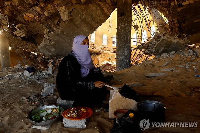 폐허가 된 건물에서 요리하는 팔레스타인인 여성  [로이터 연합뉴스 자료사진. 재판매 및 DB 금지]