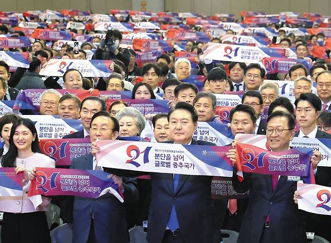 尹대통령, 민주평통 회의서 "북핵 단호히 대응" - 윤석열 대통령이 28일 경기 고양시 킨텍스에서 열린 제21기 민주평화통일자문회의 전체회의에서 참석자들과 기념 촬영을 하고 있다. 윤 대통령은 이날 개회사에서 "북한 핵 도발에 단호히 대응하고 북한 인권 문제에 대한 노력을 계속해 나가겠다"고 했다. /연합뉴스