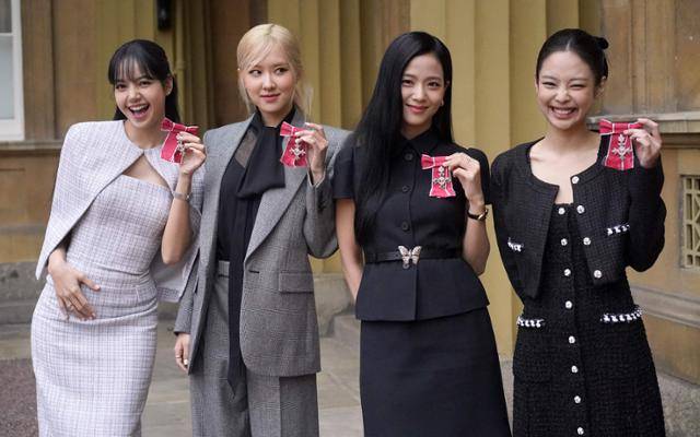 그룹 블랙핑크가 지난달 영국 런던 버킹엄궁에서 열린 문화 예술인 격려 행사에서 찰스 3세 국왕에게 받은 대영제국훈장을 들어 보이고 있다. 스탠스테드 AFP=연합뉴스