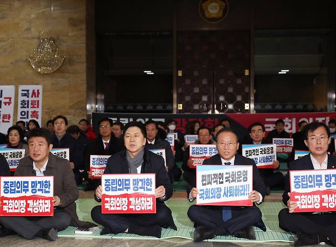 "국회의장 사퇴" 30일 국회 로텐더홀에서 국민의힘 김기현 대표(앞줄 왼쪽 둘째)와 윤재옥 원내대표(앞줄 왼쪽 셋째) 등 의원들이 모여 이동관 방통위원장을 탄핵 처리하려는 더불어민주당 계획에 항의하는 의미로 철야 농성을 벌이고 있다. 연합뉴스