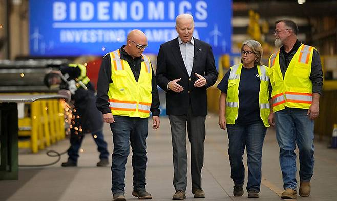 조 바이든 미국 대통령(가운데)이 29일(현지시간) 콜로라도주 푸에블로에 있는 세계 최대 풍력 생산시설 한국 기업 CS윈드 공장을 둘러보며 관계자들과 대화하고 있다. 공장에는 ‘바이드노믹스, 미국에 투자’라고 쓰인 배너가 걸렸다. 푸에블로=AP연합뉴스