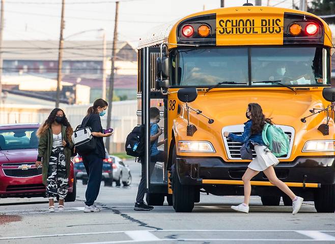 미 펜실베이니아주의 한 고교에서 지난 7일 개학을 맞은 학생들이 스쿨버스를 타고 있다. 스쿨버스 기사 부족 사태로 펜실베이니아 피츠버그 등 일부 교육구에선 개학을 몇 주 늦춰 10월께로 연기하기도 했다. /AP 연합뉴스