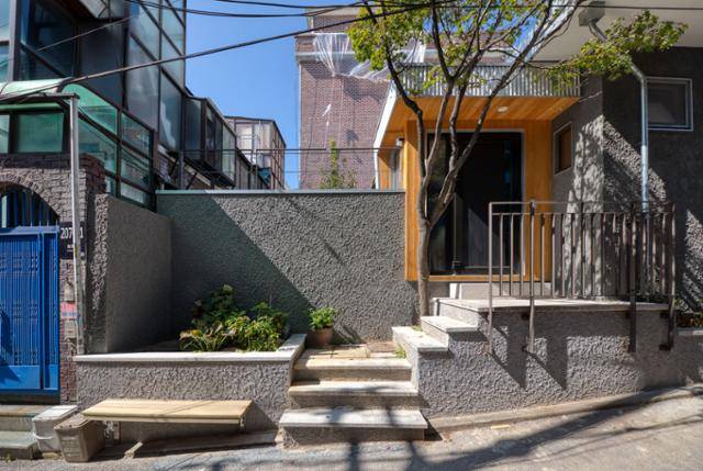 50년 된 단독주택을 고쳐 만든 솔샘주택의 외관. 이웃이 편안하게 머물도록 현관 옆에 작은 정원을 조성하고, 의자를 만든 배려가 돋보인다. 이상훈 건축사진작가 제공