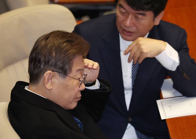 이재명 더불어민주당 대표가 12월1일 국회 본회의장에서 동료 의원과 대화하고 있다. ⓒ 연합뉴스