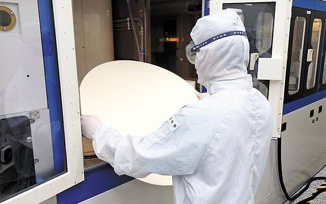 울산 KPX케미칼 공장에서 한 직원이 반도체 웨이퍼의 표면을 매끈하게 만들어주는 CMP (Chemical-mechanical polishing)패드를 살펴보는 모습. /KPX케미칼