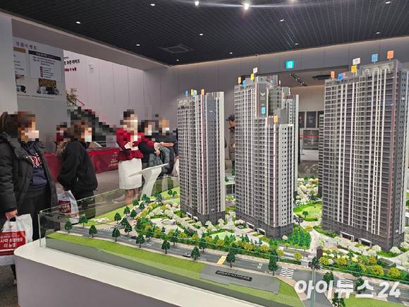 '소사역 롯데캐슬 더 뉴엘' 견본주택 방문객들이 단지 모형도를 보고 있다. [사진=안다솜 기자]