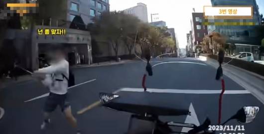 서울 도심 한복판에서 고등학생으로 보이는 한 남성이 오토바이 배달원에게 골프채를 휘두르고 있다. /사진=유튜브 갈무리