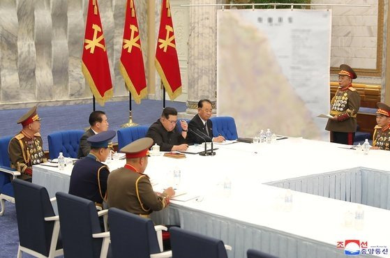 이태섭 북한군 총참모장이 22일 열린 노동당 중앙군사위원회 회의에서 동해안 축선이 담긴 작전지도를 놓고 김정은 위원장에게 설명하는 모습. 조선중앙통신, 연합뉴스.