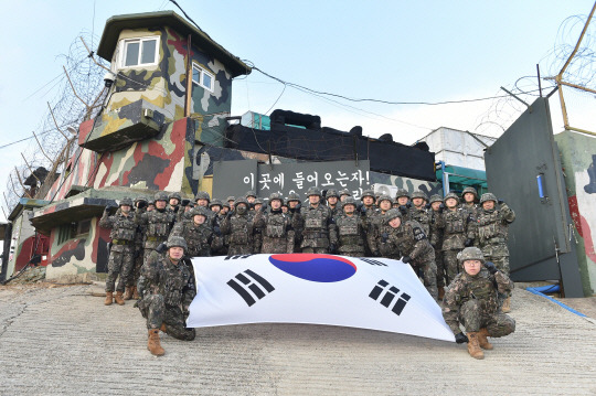 김명수 합참의장이 비무장지대(DMZ) 추진철책 점검을 마치고, 전방소초(GP) 근무 장병들에게 서울에서 공수해 간 간식(도넛)을 전달한 후 함께 화이팅을 외치며 기념촬영하고 있다. 합참 제공