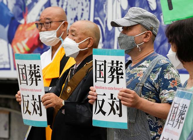 일본 도쿄 시부야에서 지난 7월 8일 아베 신조(安倍晋三) 전 일본 총리의 국장에 반대하는 플래카드를 든 사람들이 시위를 벌이고 있다/EPA연합뉴스