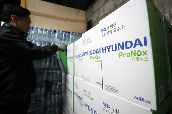 A worker organizes inventory of diesel exhaustion fluid made of urea at a gas station in Seoul on Monday. [NEWS1]