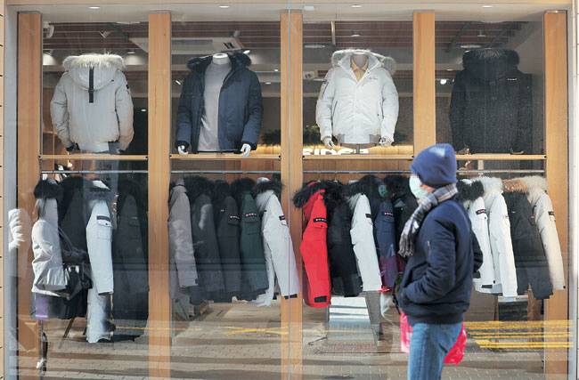 올겨울엔 숏패딩이 대세 짧은 기장의 ‘숏패딩’이 올겨울 트렌드로 떠오른 가운데 3일 한 시민이 숏패딩 등이 진열된 서울 중구의 가게 앞을 지나가고 있다. 연합뉴스