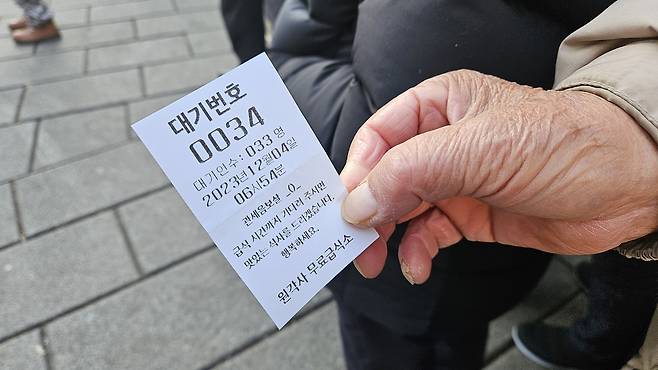 경기도 고양시에서 1시간 걸려 탑골공원에 도착한 박모(80) 씨가 원각사 노인 무료급식소에서 받은 번호표를 보여주고 있다. 박지영 기자.