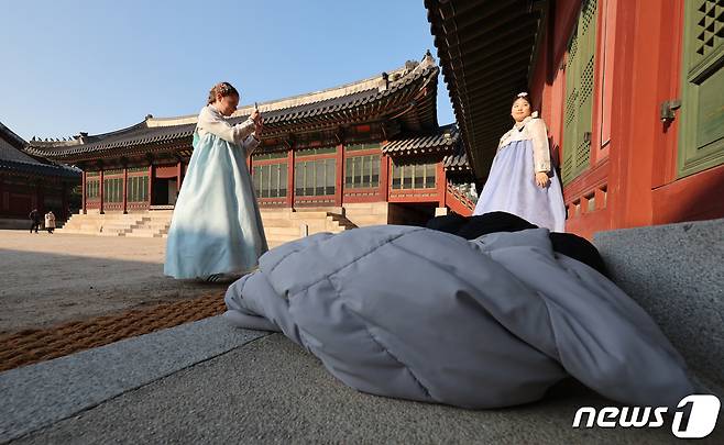 서울 낮 최고기온이 14도까지 올라가며 예년보다 온화한 날씨가 이어진 5일 오후 서울 덕수궁에서 외국인 관광객들이 겉옷을 벗고 기념 촬영을 하고 있다. 기상청은 내일 전국 대부분 지역에 초미세먼지 농도가 짙게 나타났다가 밤사이 전국 곳곳에 비가 내릴 것으로 예보했다. 2023.12.5/뉴스1 ⓒ News1 신웅수 기자