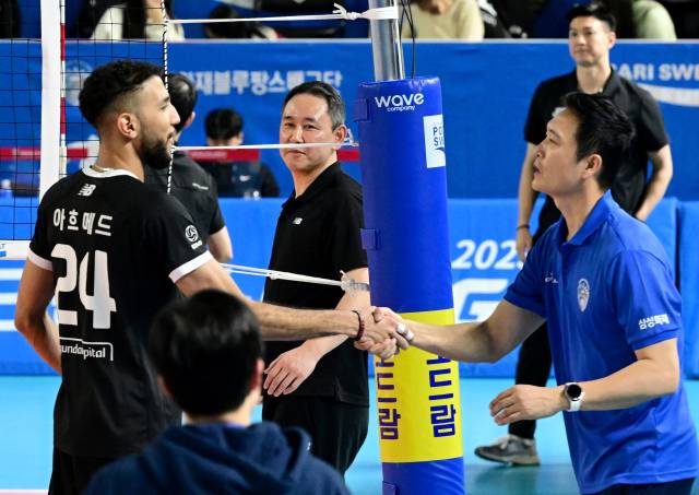 현대캐피탈 최태웅 감독이 경기 후 아흐메드가 김상우 감독에게 찾아가 인시하는 모습을 보며 미소 짓고 있다 / KOVO(한국배구연맹)