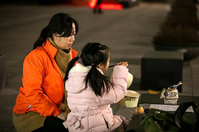 11월20일 저녁 용산 대통령실 앞에서 스텔라데이지호 침몰 참사로 동생을 잃은 허영주씨(왼쪽)가 조카와 함께 저녁 식사를 하고 있다. ⓒ시사IN 신선영