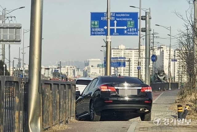 5일 오전 10시께 화성시 안녕동 일대 자전거·보행자 겸용도로 한복판에 30분이 넘도록 머무르던 검은색 승용차가 자리를 뜨고 있다. 김기현기자