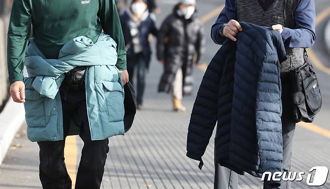 눈이 가장 많이 내린다는 절기상 대설인 7일 오후 서울 용산구 남산타워를 찾은 시민이 외투를 들고 발걸음을 옮기고 있다. 2023.12.7/뉴스1 ⓒ News1 김민지 기자