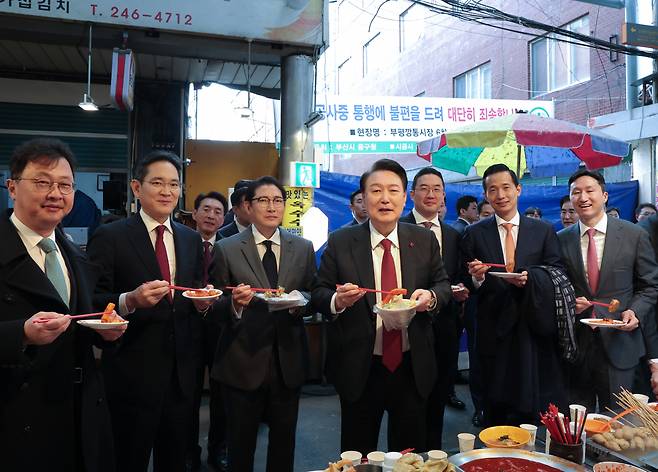 윤석열 대통령이 지난 6일 부산 중구 깡통시장에서 재계 총수들과 분식을 맛보고 있다. 왼쪽부터 최재원 SK 수석부회장, 이재용 삼성전자 회장, 조현준 효성그룹 회장, 윤 대통령, 구광모 LG그룹 회장, 김동관 한화 그룹 부회장, 정기선 HD현대 부회장. [연합]