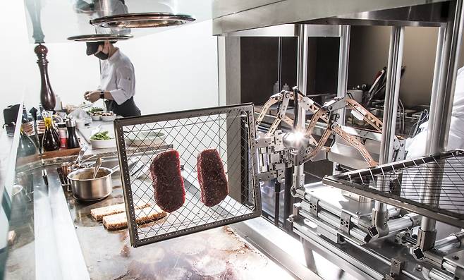 지난 5일 오전 서울 강남구 ‘안다즈 서울 강남’ 레스토랑에서 로봇 셰프가 스테이크를 뒤집고 있는 모습. 이곳 장정혜 셰프는 “로봇이 11년 차 셰프인 나만큼 스테이크를 잘 굽는다”고 했다. 이 로봇은 총주방장인 다미앙 셀므가 요리한 스테이크를 학습했다./고운호 기자