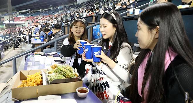 단계적 일상회복 1단계가 시작된 1일 오후 서울 송파구 잠실야구장에서 열린 2021 KBO 포스트시즌 와일드카드 결정 1차전 키움 히어로즈와 두산 베어스의 경기, 관중들이 치맥을 하며 경기를 관람하고 있다./뉴시스