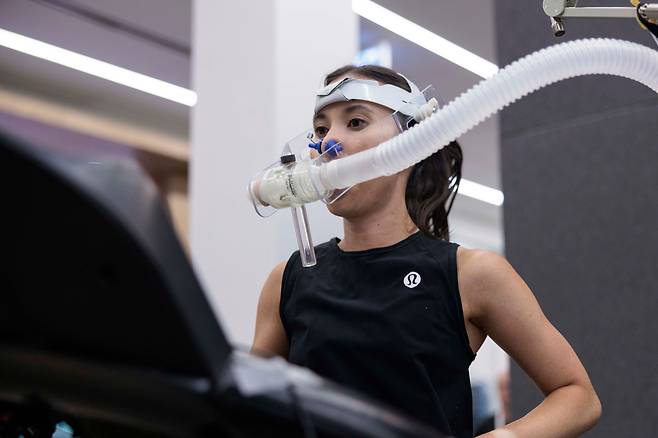 23일(현지시각) 캐나다 밴쿠버 룰루레몬 본사의 제품 혁신 실험실((Product Innovation Lab))’에서 아마추어 달리기 선수 스테파니 플리핀(33)씨가 산소포화도 체크 장비를 걸치고 트레드밀(러닝 머신) 위에 올라서서 실험에 참여하는 모습. 캐나다 올림픽·패럴림픽 선수들을 전문 코칭해온 CSIP(Canadian Sports Institute Pacific) 팀은 이 실험을 통해 여성 울트라 러너들이 운동 중 얼마나 에너지를 쓰고, 얼마나 피로를 빨리 회복하는지, 어떤 영양소를 더 소비하면서 뛰는지, 어느 속도로 달려야 최상의 결과를 낼 수 있는지를 계속해서 측정한다. 여성 선수 각자가 자신의 한계를 깨도록 돕기 위한 과정이다. /룰루레몬