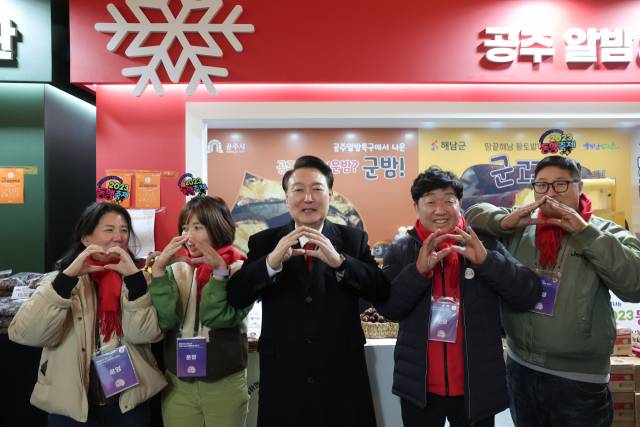 ▲윤석열 대통령이 7일 오후 서울 중구 동대문디자인플라자(DDP)에서 열린 2023년 눈꽃 동행축제 개막행사를 마친 뒤 공주알밤 부스를 찾아 관계자들과 기념촬영을 하고 있다. ⓒ연합뉴스