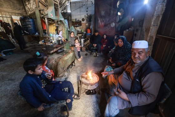 칸유니스에서 라파로 이주한 피란민 가족. 임시 거처로 삼은 공장에서 불을 피우고 옹기종기 모여있다. AFP=연합뉴스