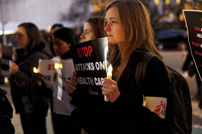 국제 의료구호 단체인 '국경없는의사회' 미국 회원들이 12월 6일(현지시간) 뉴욕 유엔본부 앞에서 이스라엘과 하마스 간 즉각적인 휴전을 호소하고 있다. 이스라엘이 하마스 본부가 있는 곳으로 지목된 의료시설 등에 대한 공습을 이어가면서 의료진들의 희생도 커지고 있다. 사진=AP·연합뉴스
