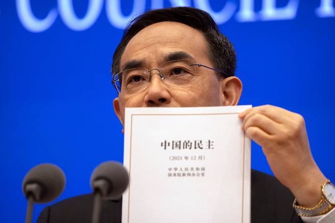 4일(현지 시각) 쉬린 중국 국무원 신문판공실 주임이 베이징 청사에서 '중국의 민주' 백서 표지를 공개하고 있다. '중국의 민주'는 중국식 민주 모델의 우월성을 강조하는 내용을 담았다/AP 연합뉴스