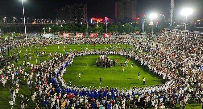 시합 전 축제 - 지난달 13일 중국 구이저우성 룽장현(縣)에서 열린 ‘2023년 룽장 농촌 축구 리그’ 경기 시작을 앞두고 관람객과 선수단 등이 축구장에서 축제를 벌이고 있다. 중국 농촌 청년들이 뛰는 ‘시골리그’는 프로 축구와 달리 엄격한 규칙을 중시하기보다 경기와 분위기를 즐기는 데 초점을 맞추고 있다. /당다이셴펑망