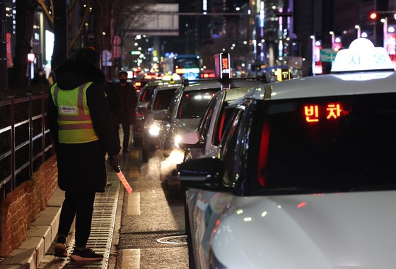지난해 12월 1일 서울 강남역 인근에서 서울시 직원과 택시 업계 관계자들이 시민들의 택시 탑승을 돕고 있다.    연합뉴스